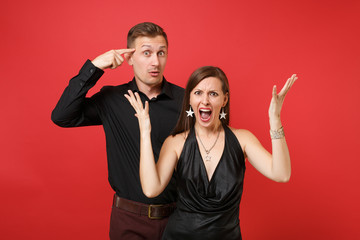 Fun expression young couple in black clothes shirt dress celebrating birthday holiday party isolated on bright red background. St Valentine International Women Day Happy New Year 2019 concept. Mock up