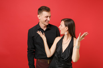 Fun expression young couple in black clothes shirt dress celebrating birthday holiday party isolated on bright red background. St Valentine International Women Day Happy New Year 2019 concept. Mock up