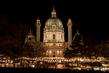Fototapeta na wymiar Christkindlmarkt – Adventmarkt – Weihnachtsmarkt Wien / Österreich. Weihnachtsdorf vor der Karlskirche am Karlsplatz