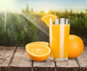 Glass of delicious orange juice on natural background