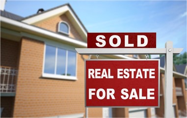 Real estate sign in front of new house for sale