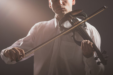 The musician plays the electronic violin. Violin close up.