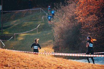 Cross country race. Female Athlete runs up hill