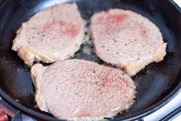 Beef medallion steaks frying in a pan