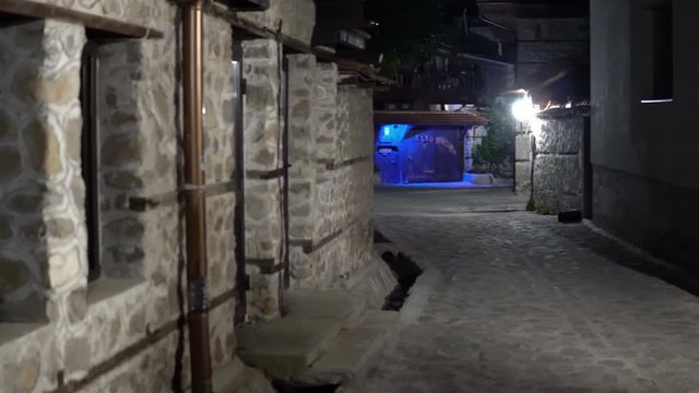 Vintage dark alley at night. Old house and street architecture in Bansko, Bulgaria