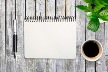 Coffee, notepad and pen on wooden background