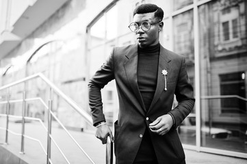 Amazingly looking african american man wear at blue blazer with brooch, black turtleneck and glasses posed at street. Fashionable black guy.