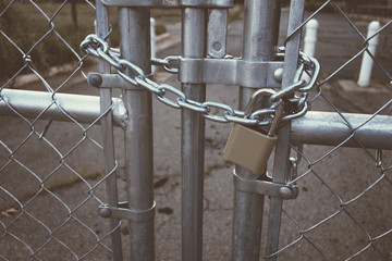 Locked Gate/Boarder Tethered by metal chain and padlock. Toned photo. Closed borders immigration concept.
