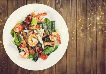 Green salad with shrimps on background