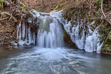 Wasserfall am Wildbach mit Eisablagerungen nach tagelangem Frost