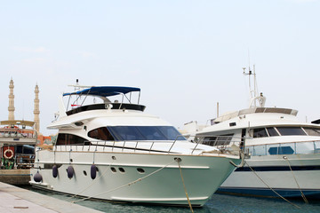 Fototapeta na wymiar Motor white yacht at the pier in the marina of Hurghada.
