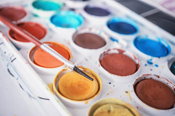 Close-up of color paints with a brush. Paints used by the artist, prepared for drawing