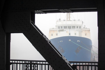 the nose of a huge ship in a thick fog