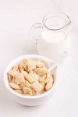 Crispy corn pads in bowl with jar of fresh milk