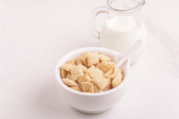 Crispy corn pads in bowl with jar of fresh milk
