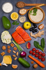 Flatlay setting of healthy food: fish salmon, bowl of rice, avocado, fruits and vegetables. Balanced diet, food background