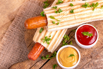 Two tasty grilled french hot dog with mustard and ketchup