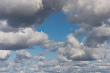 Beautiful white and grey fluffy clouds soar over a deep blue background. Cloudscape with autumn...