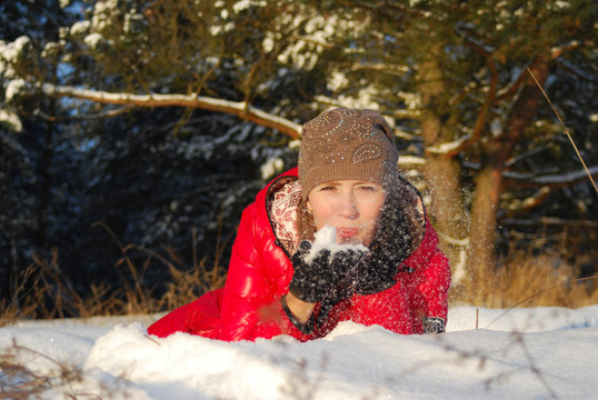 girl near a Christmas tree in the street in a forest in a red jacket and a knitted white hat snow is happy nature in winter a positive photo of a snowfall