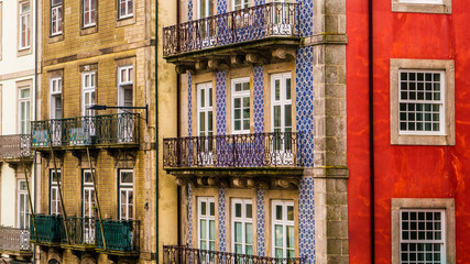 Fototapeta na wymiar Row of old, colorful buildings with ornate balconies and tiles line a street in Porto, Portugal
