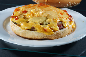 Delicious hamburger with cheese and ketchup prepared in the kitchen and photographed in the studio 