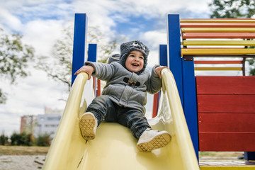 Little Boy on Slide in Park In Winter