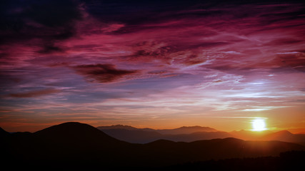 Fototapeta na wymiar silhouetted highlands under a violet overcast sunset sky