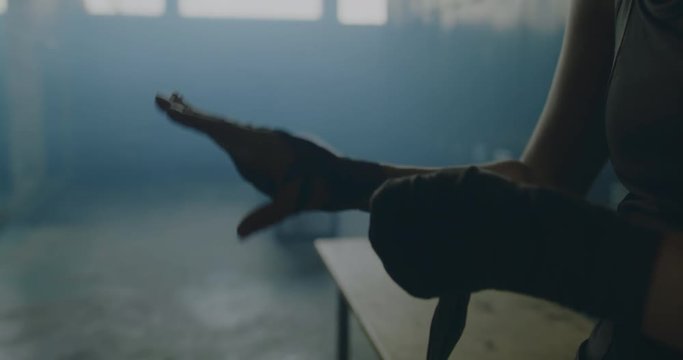 CU Caucasian female wraps her hands in locker room before boxing martial arts training. 4K UHD 60 FPS SLOW MOTION