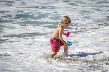 Little Boy Playing With Beach Toys in the Ocean