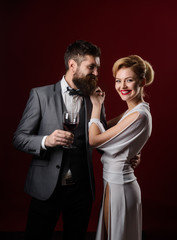 Elegant couple with red wine. Romantic couple spending time together. Handsome man with glass of wine hugs beautiful woman. Happy couple drinking glass of wine. Girl flirting with man with glass wine.
