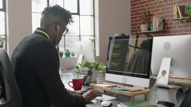 portrait african american man programmer coding network security software for startup company professional web developer typing code on computer screen listening to music in successful office 