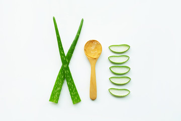 Aloe vera fresh leaves with slices and aloe vera gel on wooden spoon. isolated on white