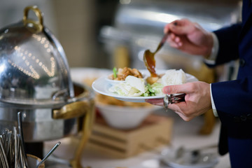 scooping the food, buffet food at restaurant, catering 
