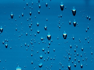 Shiny water drops and shadows on the blue background