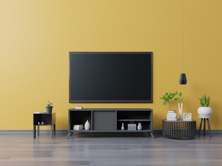 TV on yellow wall background have cabinet in modern living room with lamp,table,flower and plants ,3d rendering
