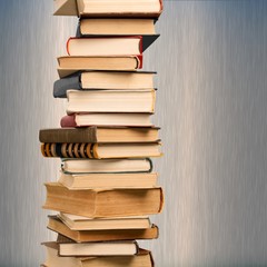 Collection of old books vertical stack on beige background
