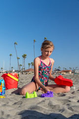 Caucasian Girl Playing with Beach Toys in the Sand at the Beach