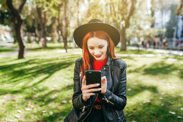 Close up portrait of a young stylish woman holding a smartphone