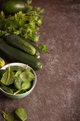 Fresh green vegetables in a bowl and on the table