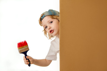 boy painter. A small artist with a paint brush in his hands with red paint looks out from behind the wall.