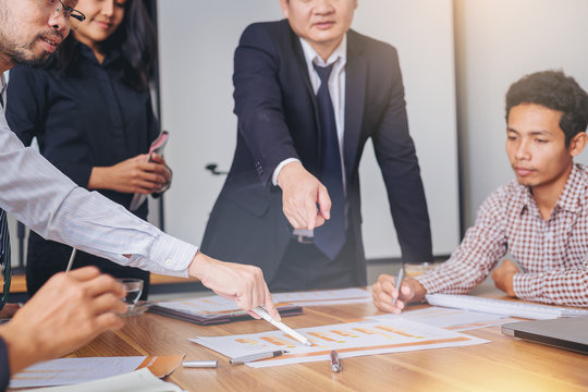 Businesspeoples meeting pointing to graph in business report on the table for startup new project