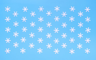 Christmas pattern of small white snowflakes on light blue background