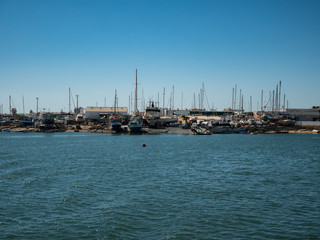Fototapeta premium Boat yard in Algarve region, Portugal with several boats in various stages of repair on a sunny summer day with blue sky.