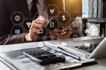 Businessman hands working with finances about cost and calculator and laptop with tablet, smartphone at office with VR icon in morning light