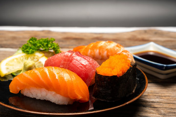 Sushi salmon & tuna sushi shrimp and wasabi on the white plate. on the wood table