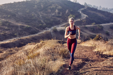 Beautiful Caucasian White Woman Runs on a Trail in the Morning Sunlight