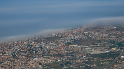 High altitude Aerial shot of Povoa de Varzim, Porto district in Portugal from plane with thick clouds over the Atlantic coast