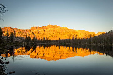 Fototapeta na wymiar Reflection of Mountain at Sunset on Glassy Surface of Lake
