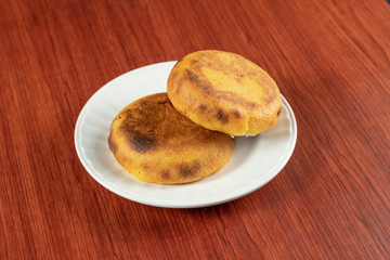 A fresh hot Arepa popular in Colombia and Venezuela made of two corn cakes that are fried until cheese between them melts, food