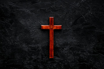 Funeral concept. Wooden cross on black background top view copy space